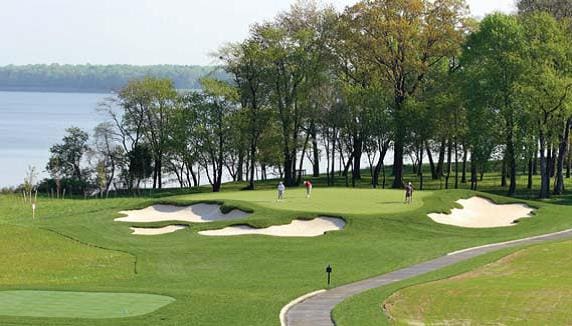 Golf course with sand traps and golfers, possibly for Providence's Moran Golf Classic.